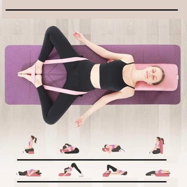 Femme allongée sur le dos en appui la tête et les épaules sur le traversin de couleur rose éco de suède adhocia. Les jambes croisées en crapaud le tout en étirement aidée de la sangle de couleur rose de yoga adhocia, le tout sur le tapis d'alignement d'adhocia