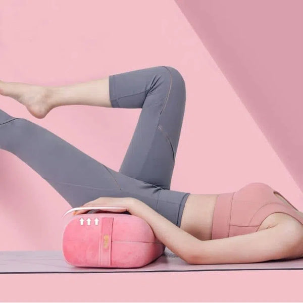 Femme allongée, le bassin en appuie sur le traversin de yoga de couleur rose, la jambe droite en l'air fléchie, le tout sur le tapis Vegan adhocia